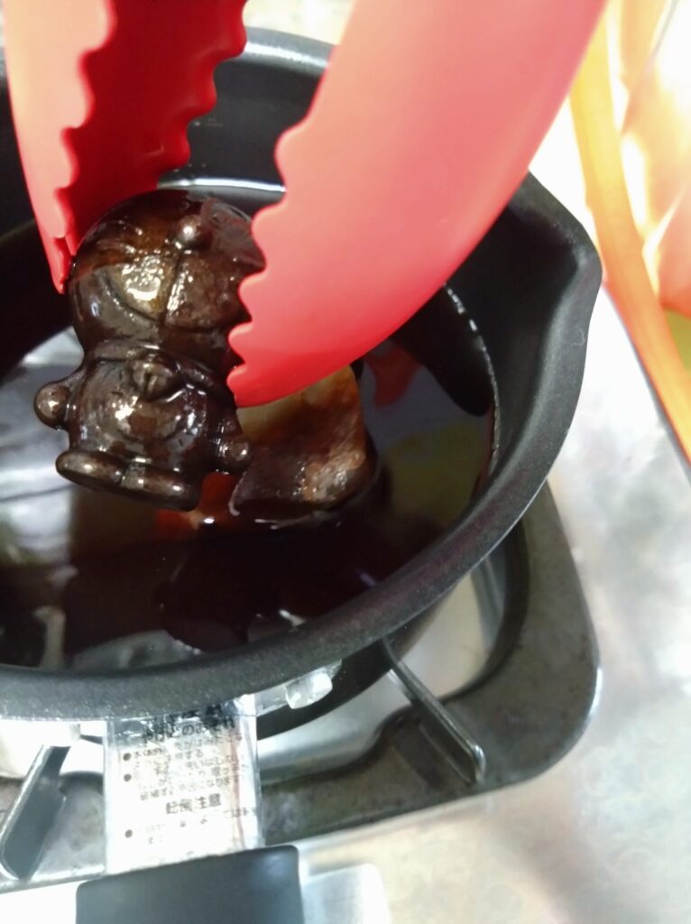 煮立たせたお茶から鉄玉を取り出す